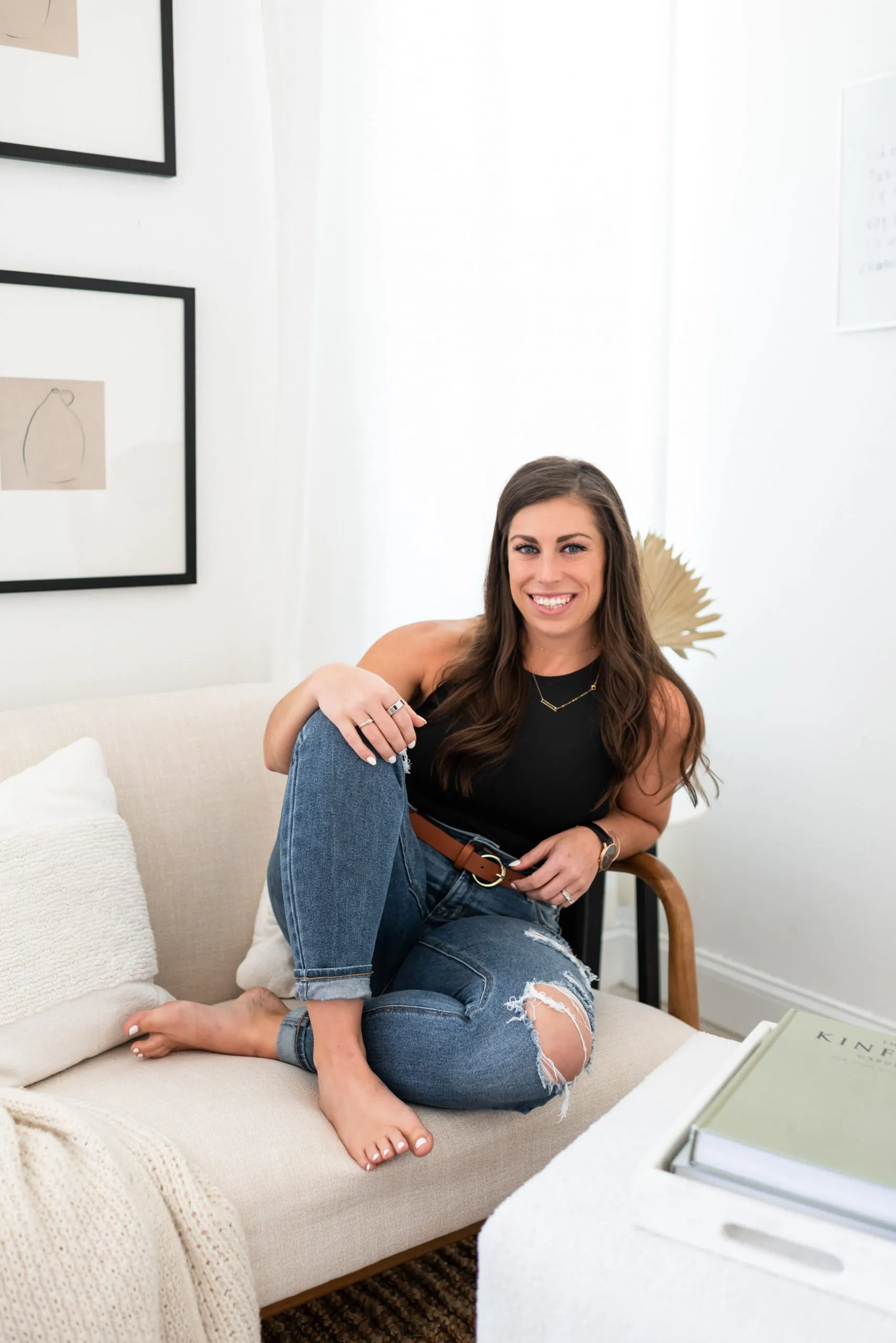 A photo of Dr. Jen Hosler, a licensed physical therapist and mobility specialist, sitting on a couch smiling.